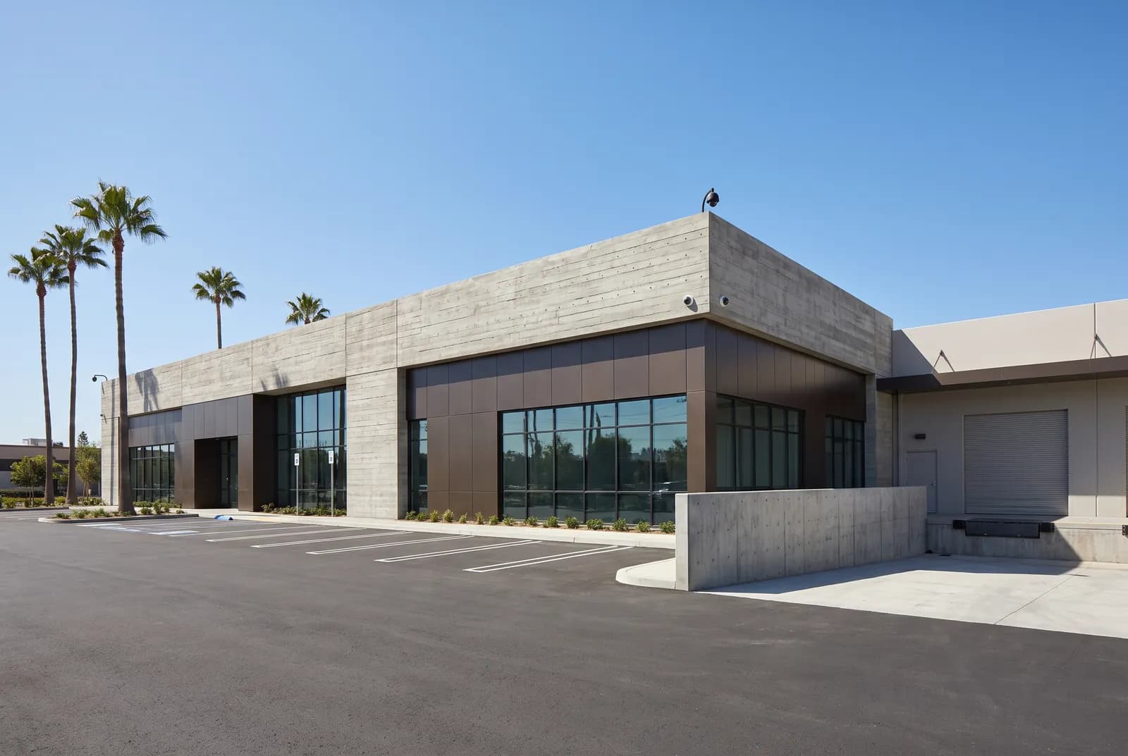 Modern California commercial building exterior with security cameras covering the perimeter and service entrance